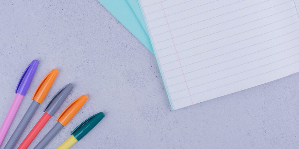 White blank notebook with pens on grey background. High quality photo